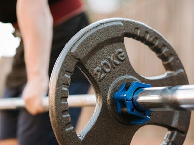 Man hands gripping a metal barbell before a lift